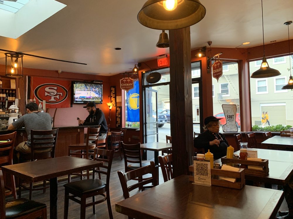 Inside Bistro Gambrinus — warm terracotta walls, dark wood tables and brass lamps